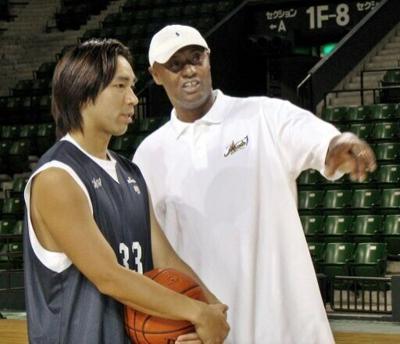 Former NBA player Joe Bryant, right, has died at age 69. The father of the late NBA superstar Kobe Bryant instructs Japanese player Taketo Aoki during his time coaching in Tokyo