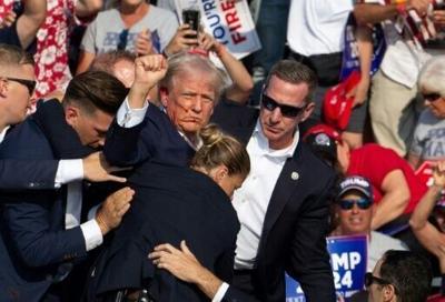 Republican candidate Donald Trump was pictured seen with blood on his face surrounded by secret service agents after the assassination bid